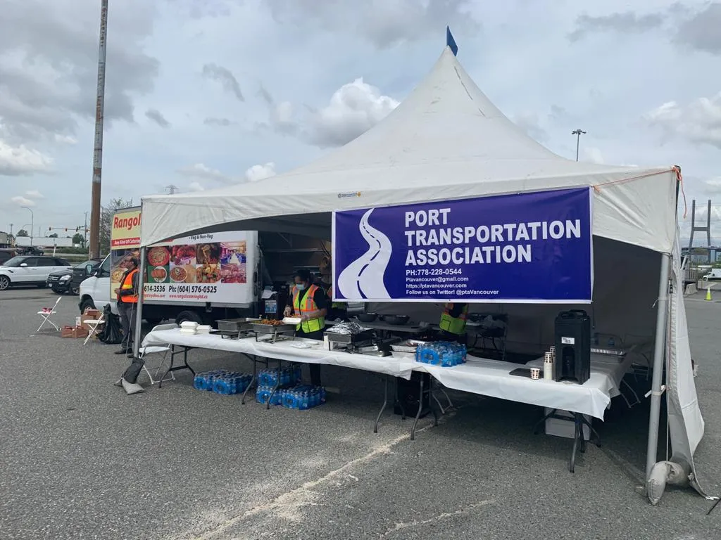 The event tent with the PTA banner, serving tables with hot food and cases of bottled water, and the Rangoli Catering & Sweets truck alongside