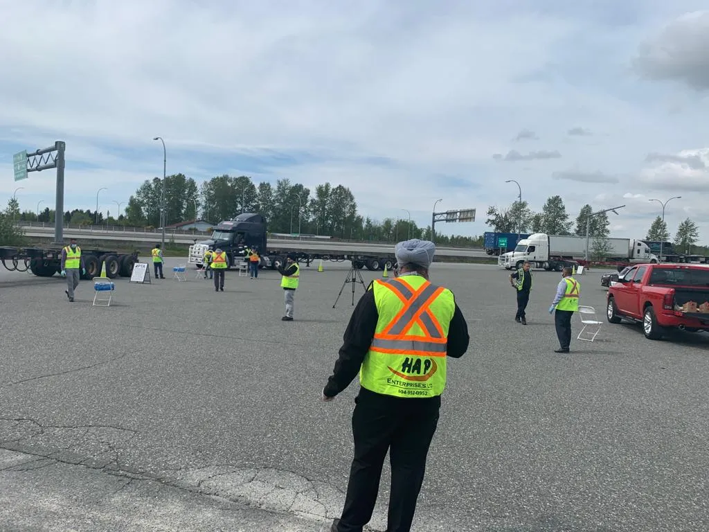 Volunteers in safety vests spread across the Nordel scale lot as semi-trucks line up in the background